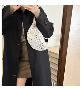 Detalle de lunares de colores sobre bolso de silla blanco con correa ajustable y hebilla