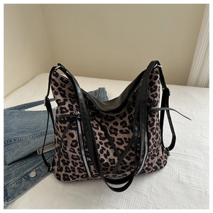 Dettaglio borsa leopardata con cerniere argentate e cinturini in pelle nera
