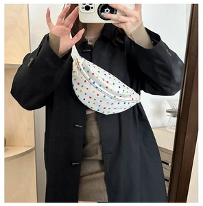 Detailed close-up of a white canvas waist bag featuring colorful polka dot patterns