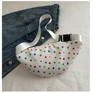 Close-up of white canvas waist bag with colorful polka dots and nylon strap details