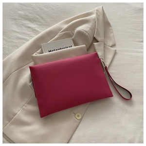 Detail of fuchsia envelope clutch bag with leather wristlet strap on a blazer