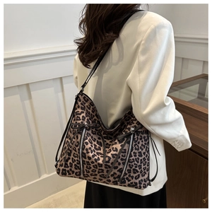 Detail of leopard print hobo bag with dual zipper accents and adjustable shoulder strap