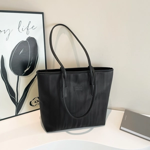 Large black tote bag with vertical zebra texture and shoulder strap on display stand