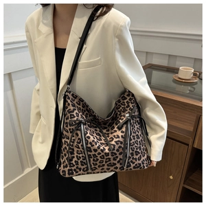 Detalle de bolso con estampado de leopardo con cremalleras decorativas y lazos suaves