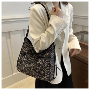 Detalle del bolso tote con estampado de leopardo, bolsillos de cremallera y correas negras