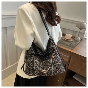 Detalle del bolso tote de leopardo con cremalleras y lazo decorativo al hombro