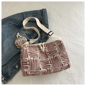 Dettaglio di una borsa tote a righe con portamonete rotondo abbinato su una giacca di jeans