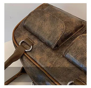 Close-up of vintage brown cracked leather tote bag texture and silver metal hardware