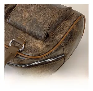 Close-up of vintage brown leather cylinder bag with textured finish and silver hardware