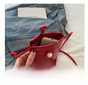 Petit sac rouge à perle montrant la capacité intérieure pour téléphone et accessoires