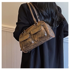 Detail of vintage brown distressed leather shoulder bag with two front flap pockets