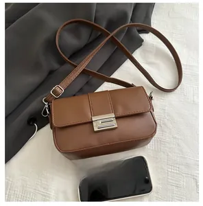 Borsa a tracolla in pelle PU marrone con chiusura argento e smartphone per confronto
