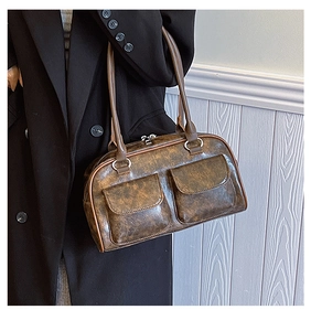 Detail view of the vintage brown faux leather texture and retro buckle on the shoulder bag