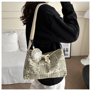 Dettaglio della borsa in maglia verde e beige con mini portamonete e tracolla abbinata