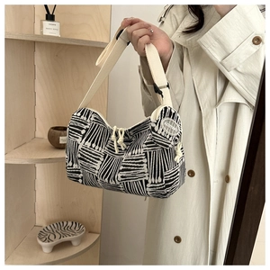 Dettaglio della borsa tote in tela jacquard a righe bianche e nere con tracolla regolabile