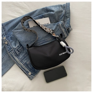 Detail of OOTMAO black nylon dumpling bag with geometric woven strap on casual outfits