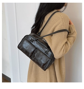 Detailed view of dark brown vintage texture and metal hardware on underarm bag