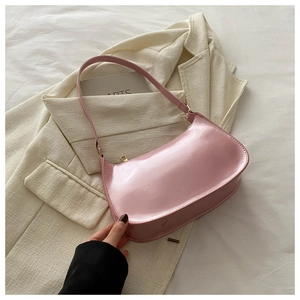 Detailed view of pink patent leather hobo bag with glossy finish and gold zipper