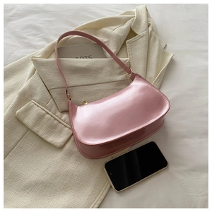 Detailed view of pink patent leather bag showing high-gloss texture and storage capacity