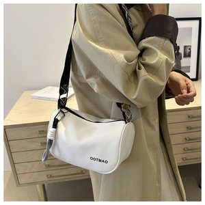 Close-up of white boston bag with black and white geometric wide shoulder strap detail