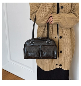 Detail of vintage brown tote bag showing dual front magnetic pockets and faux leather texture