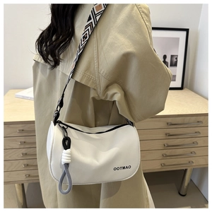 Detail of white Oxford fabric crossbody bag with geometric jacquard wide strap and pendant