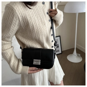 Elegante borsa a tracolla quadrata in pelle nera con fibbia in metallo in un interno moderno