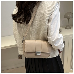 Borsa a tracolla squadrata minimalista color crema con fibbia argento indossata da modella