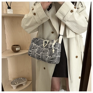 Dettaglio del motivo geometrico bianco e nero sulla borsa tote in tela con tracolla larga