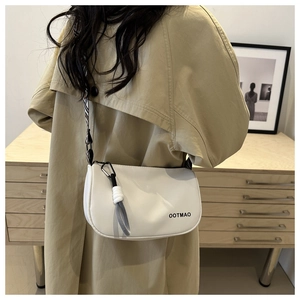 Close-up of white leather crescent bag with striped strap and OOTMAO lettering detail