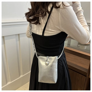 Détail du mini sac bandoulière argenté avec une grande boucle en perle élégante