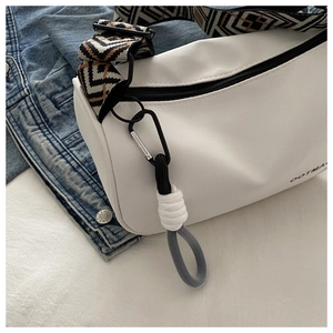 Close-up of white waterproof oxford dumpling bag with geometric pattern strap and hardware