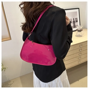 Detail of glossy pink patent leather shoulder bag with golden metallic zipper and slim strap