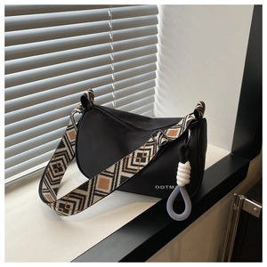 Detail of black crossbody dumpling bag with geometric pattern wide shoulder strap