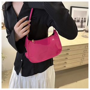 Detail of bright pink patent leather baguette bag with a sleek gold zipper closure