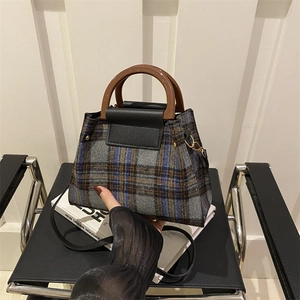 Detail of checkered plaid handbag with round resin handles and black leather strap