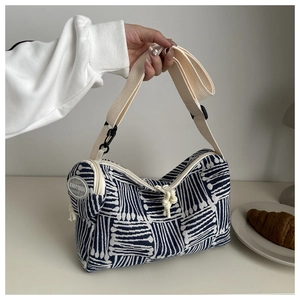 Dettaglio della borsa tote a righe blu e beige con tracolla e piccolo portamonete tondo
