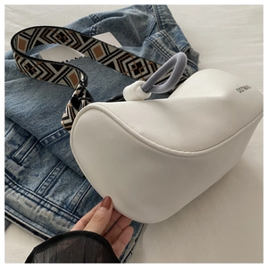 Detail of white Oxford fabric crossbody bag with OOTD print and geometric woven strap
