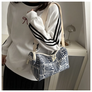 Dettaglio della trama a maglia e della zip con nodo di una borsa a righe blu