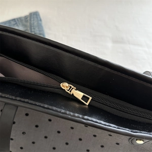 Detail of star print tote bag featuring a gold zipper closure and polka dot lining