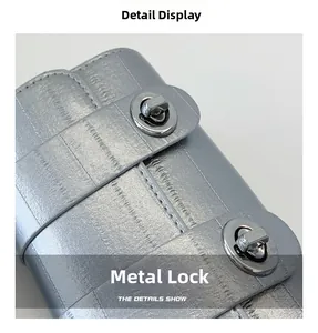 Close-up of dual silver metal twist locks on textured leather small square bag