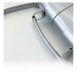 Macro detail of silver textured leather handbag showing metal buckle and stitching