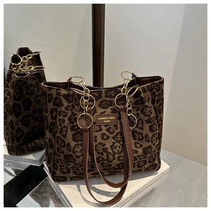 Detail of leopard print tote bag with brown leather brand tag and gold chain strap