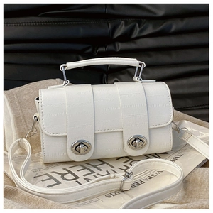 Detail of white croc-embossed handbag with dual silver turn-lock closures and top handle