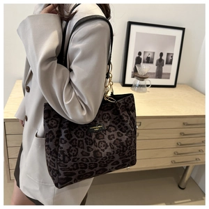 Macro shot of stylish leopard print shoulder bag with gold chain and brand plate detail
