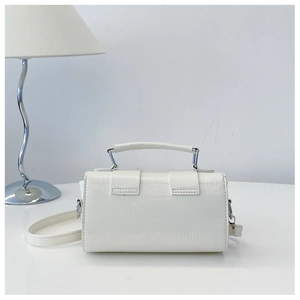 Detail of white crocodile pattern shoulder bag with handle and silver hardware
