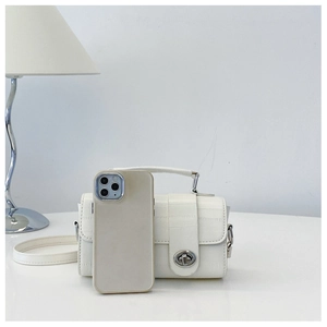 White crocodile pattern mini bag shown next to a smartphone to demonstrate size and capacity