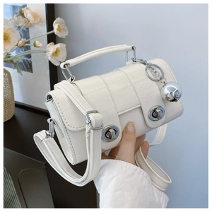 Detail of white crocodile texture mini bag with silver ball charm and double twist locks