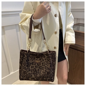 Leopard print tote bag detail showing leather strap and golden metal chain link hardware