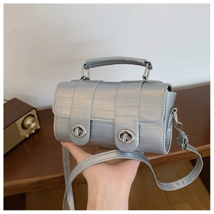 Detail of silver metallic faux leather bag with dual metal turn-locks and fine texture